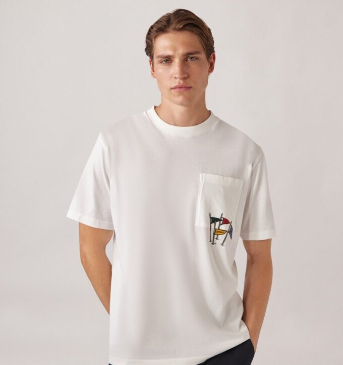 UNISEX-T-SHIRT MIT FLAGGEN-TASCHE UNISEX-T-SHIRT MIT FLAGGEN-TASCHE